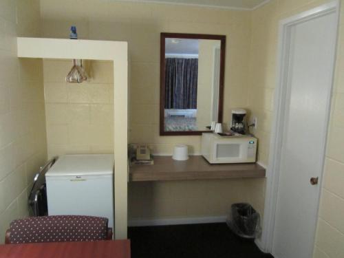 a small bathroom with a microwave and a mirror at Relax Inn - Cottage Grove in Cottage Grove