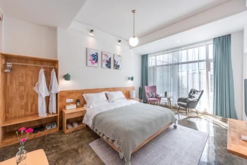 a bedroom with a bed and a large window at Shang Shan ruo shui 大理上山若水客栈 in Dali