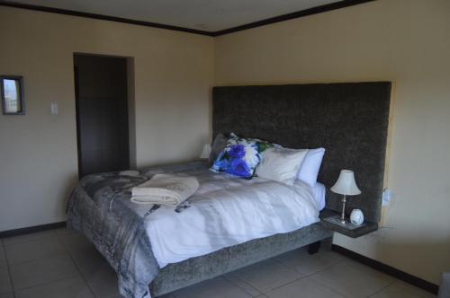 a bedroom with a large bed with white sheets and pillows at Oppidam Self Catering Accommodation in Clanwilliam