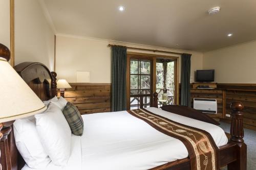a bedroom with a bed and a television at Cradle forest inn in Moina