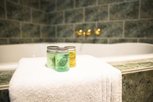 two jars on a towel in a bathroom with a bath tub at Cradle forest inn in Moina