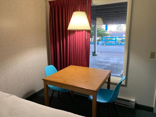 a room with a table and two chairs and a window at Pacific Sunset Inn in Brookings