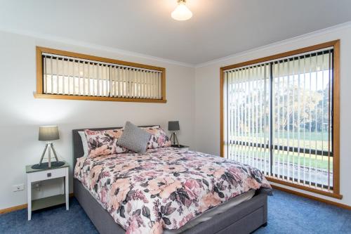 a bedroom with a bed and a large window at Acton Park Holiday Units in Acton Park