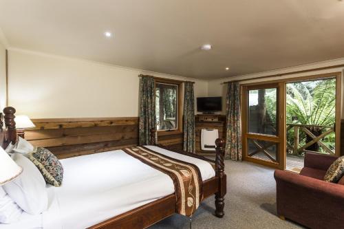a bedroom with a bed and a chair and a window at Cradle forest inn in Moina