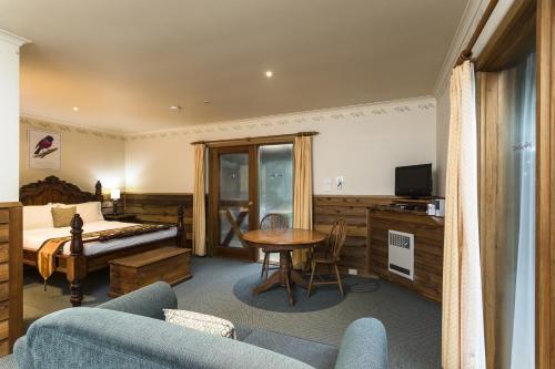 a bedroom with a bed and a table in a room at Cradle forest inn in Moina