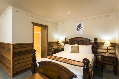 a bedroom with a bed and a dresser at Cradle forest inn in Moina