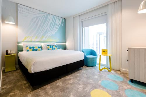a bedroom with a bed and a large window at ibis Styles East Perth in Perth