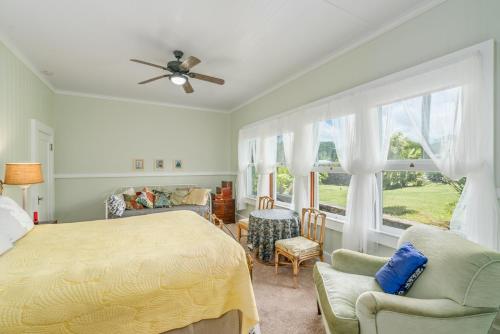 a bedroom with a bed and a couch and a window at Old Hawaiian Bed and Breakfast in Hilo