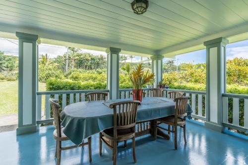 eine abgeschirmte Veranda mit einem blauen Tisch und Stühlen in der Unterkunft Old Hawaiian Bed and Breakfast in Hilo