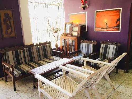 un soggiorno con un divano, un tavolo e delle sedie di White House a Negombo