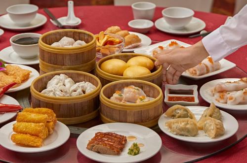 a table with plates of food and bowls of food at Fortuna Hotel Hanoi in Hanoi
