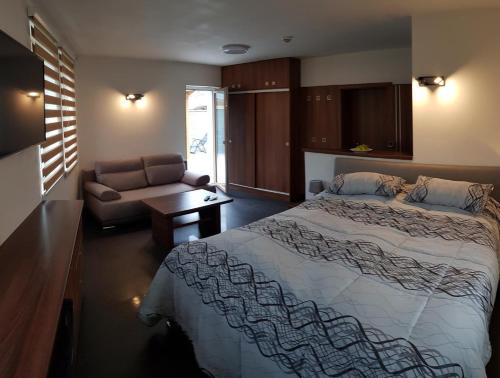 una camera con un grande letto e un divano di Apartmány Meandry a Mimoň