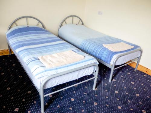 two beds sitting next to each other in a room at Beaconsfield Hotel in London