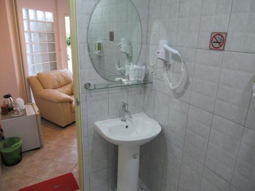 a bathroom with a sink and a mirror on the wall at Villa Oranje Pattaya in Pattaya