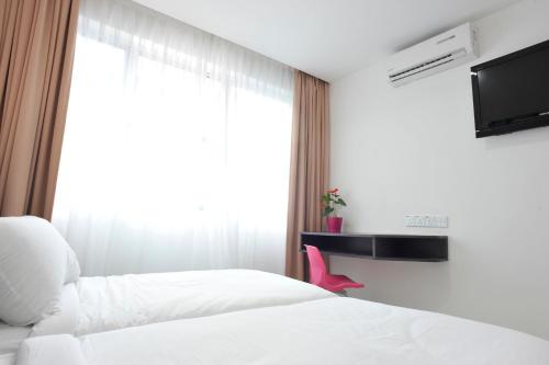 a hotel room with two beds and a window at V Hotel Kuala Lumpur in Kuala Lumpur
