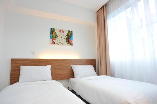 a bedroom with two beds and a window at V Hotel Kuala Lumpur in Kuala Lumpur