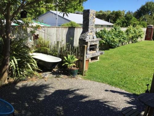 a garden with a bath tub next to a fence at Sundari Retreat in Otaki