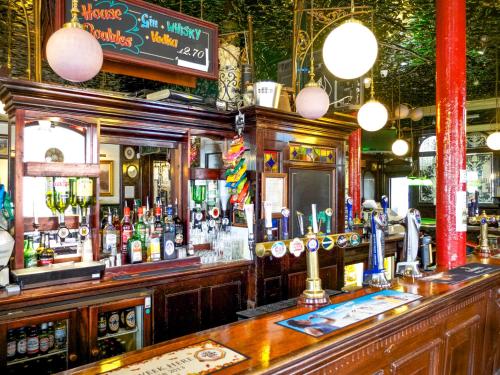 a bar in a pub with a lot of alcohol at Beaconsfield Hotel in London