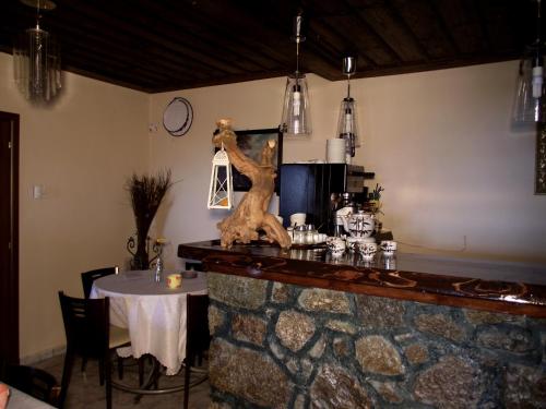 a dining room with a table and a stone counter at Panorama Prespes in Agios Germanos