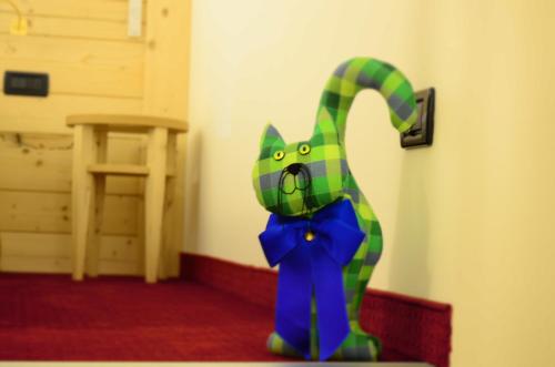 a green and blue cat decoration in a room at Hotel Ladina in Campitello di Fassa