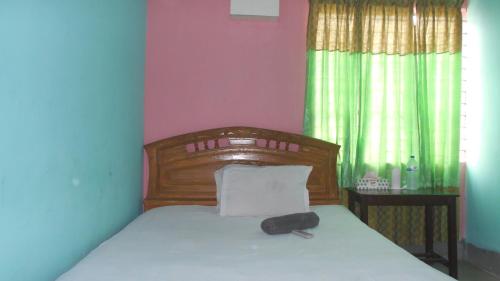 a bedroom with a bed with a black remote control on it at Hotel As Shams International in Dhaka