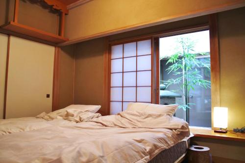 a bed in a room with a large window at 藤花楼 KAMAKURA in Yamanouchi