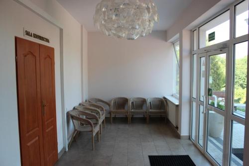 a waiting room with a row of chairs and a chandelier at Na Skarpie in Olsztyn