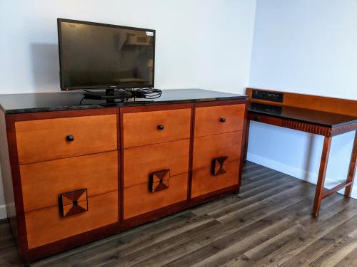 a wooden dresser with a television on top of it at Executive Inn in Thomson