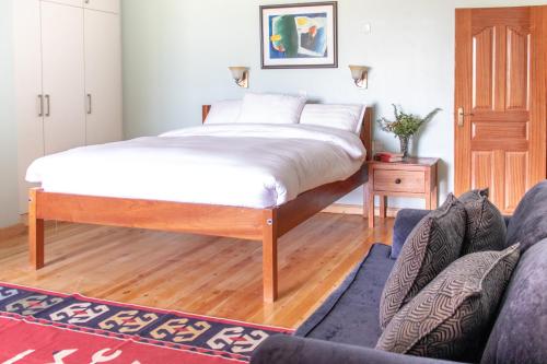 a bedroom with a large bed and a couch at Mount Kenya Farm Stay in Nanyuki