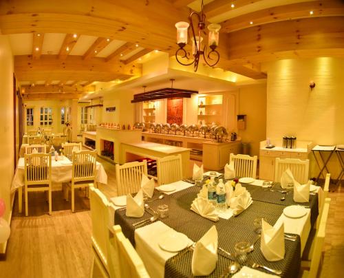 a restaurant with tables and chairs in a room at Hotel Indriya Wayanad in Kalpetta