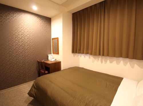 a bedroom with a bed and a desk and a window at Hotel Trend Tobu Asakusa-Eki Kita in Tokyo