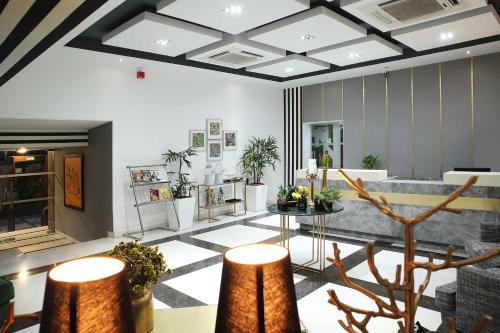 a lobby with a waiting area with plants and tables at Ahuja Residency Sunder Nagar in New Delhi