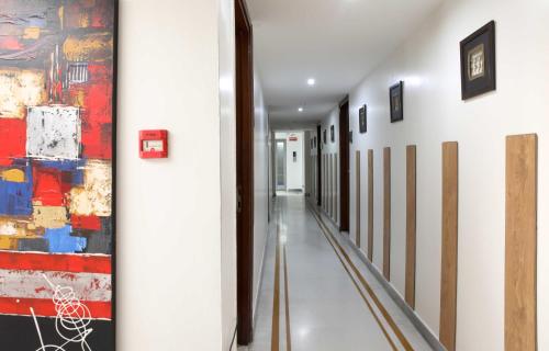 a hallway with a painting on the wall and a hallway sidx sidx sidx at Ahuja Residency Sunder Nagar in New Delhi