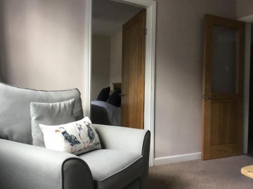 a living room with a chair with a pillow on it at Mount Pleasant Apartments in Beaumaris