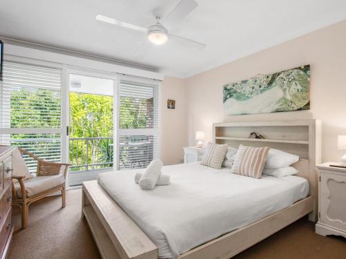 a bedroom with a large bed and a window at Ardem at Byron in Byron Bay
