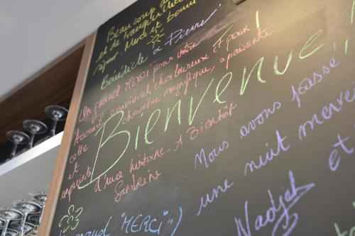 a chalkboard with writing on it on a table at 5 Chambres en Ville in Clermont-Ferrand