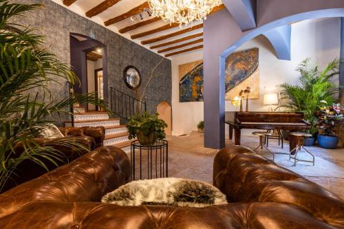 a living room with leather couches and a piano at El Palauet del Priorat in Cornudella
