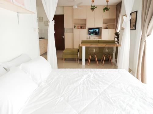 a bedroom with a white bed and a dining room at Vaincation at Ritze Perdana 2 Damansara Perdana in Petaling Jaya