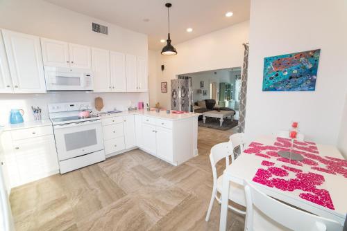 a kitchen with white cabinets and a table with chairs at PETIT BOUT DE FRANCE in St. Augustine