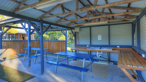 a pavilion with a blue picnic table and benches at Nambucca River Village by Lincoln Place in Macksville
