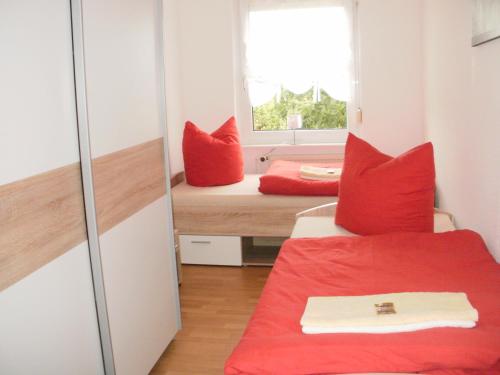 a room with two beds with red pillows and a window at Ferienwohnung mit Balkon in Zwenkau