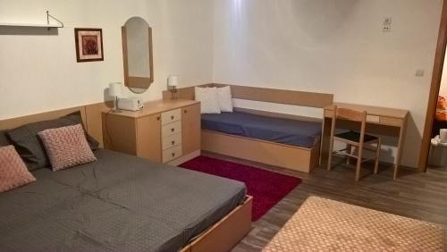 una piccola camera con letto, scrivania e letto di Apartman-Vila Nikola, 064jedansedamdvatridevetnulatri a Kopaonik