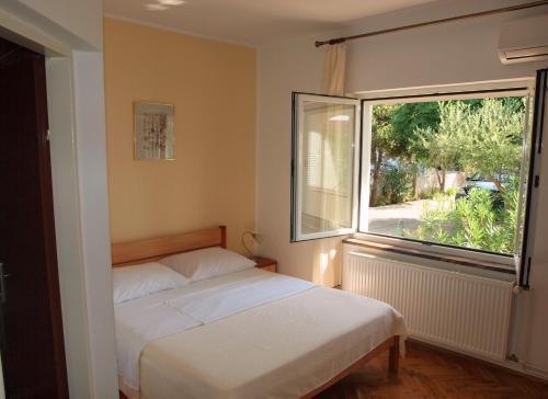 sypialnia z łóżkiem i dużym oknem w obiekcie Ana Guest House w Nin