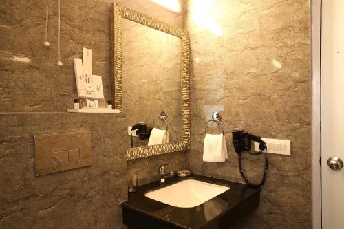 a bathroom with a sink and a mirror at Ahuja Residency Sunder Nagar in New Delhi