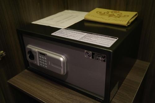 a microwave on a shelf with a book on top of it at ELIZABETH HOTEL in Thu Dau Mot