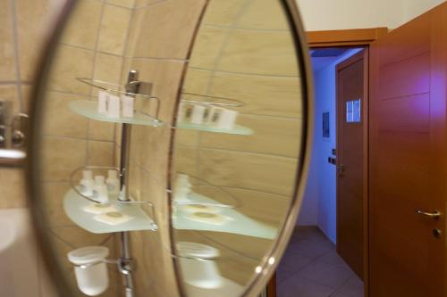 a mirror in a bathroom with two sinks and a shower at Hotel Portonuovo in Vieste