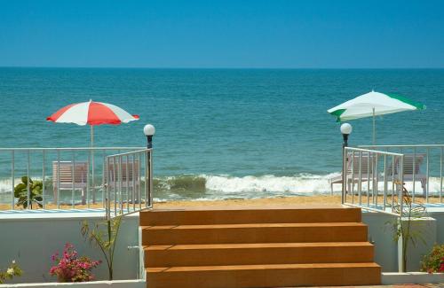 a beach with chairs and umbrellas and the ocean at Sealine Beach Resorts in Cherai Beach