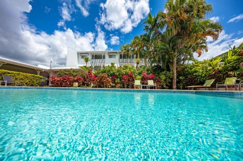 a large swimming pool in front of a house at City Terraces Cairns in Cairns