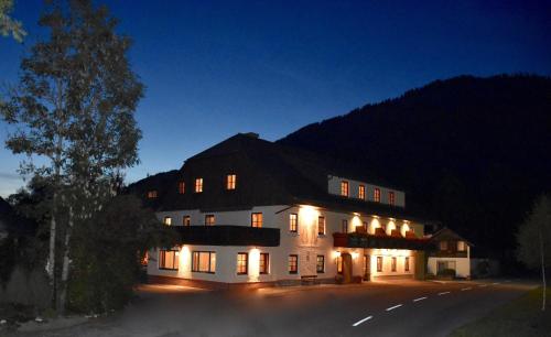 a large white building with lights on it at night at Sport Aktiv Pension Spanner - Tauplitz in Bad Mitterndorf