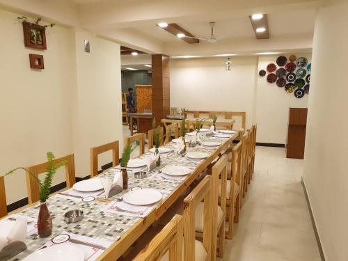 una lunga sala da pranzo con un lungo tavolo e sedie di Hotel Devlok Primal a Mussoorie
